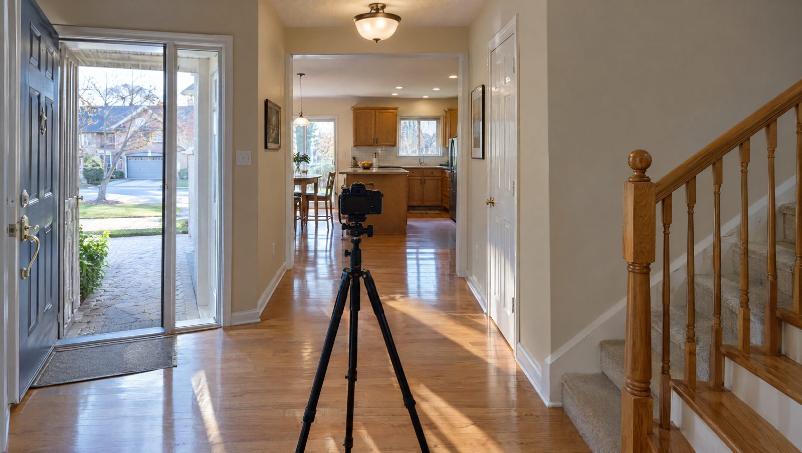A camera on a tripod in the front hallway of a Vaughan house, pointed at the kitchen